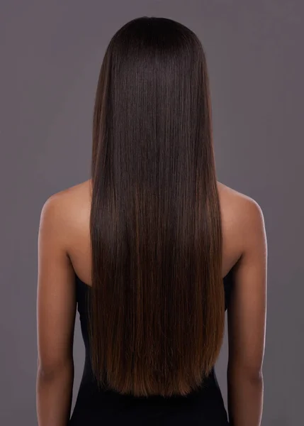 Cabello impecable... gracias a su hierro plano de confianza. Vista trasera de una mujer joven con hermoso pelo largo. —  Fotos de Stock