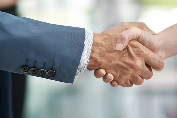 Extending a warm welcome. Closeup shot of businesspeople shaking hands in a modern office. — стоковое фото