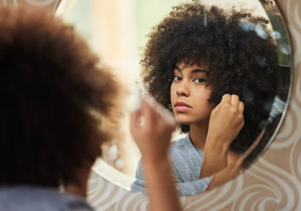 Vida elétrica e alma. Retrato de uma bela mulher olhando no espelho enquanto aplica maquiagem em casa. — Fotografia de Stock