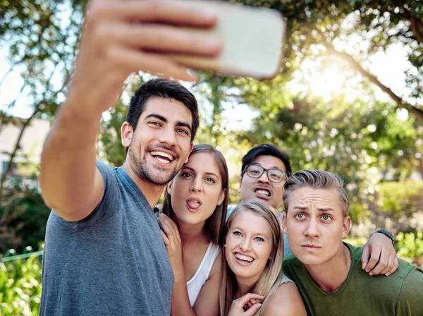 Bevarar ögonblicket. Beskuren bild av en ung grupp vänner som tar selfies medan du njuter av några drinkar utomhus i sommarsolen. — Stockfoto