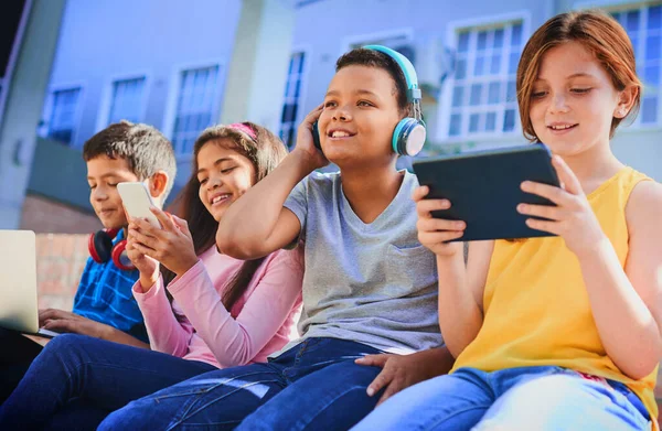 El futuro es nuestro para crear. Foto de un grupo diverso de niños divirtiéndose con la tecnología fuera. —  Fotos de Stock