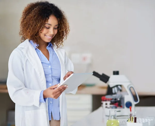 Aufzeichnung der Ergebnisse. Schnappschuss einer attraktiven jungen Frau, die im Labor Daten auf ihrem Tablet aufzeichnet. — Stockfoto