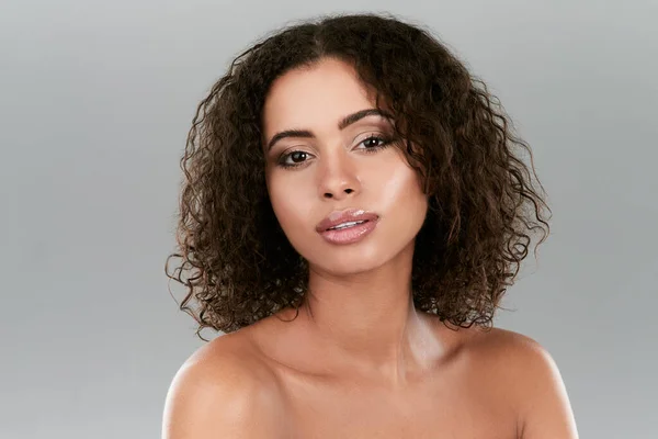 Her skin glows from looking after it. Studio shot of a beautiful young woman posing against a gray background. — Foto de Stock