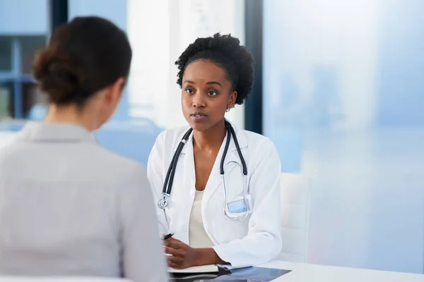 Jakékoliv příznaky, kterých bych si měl být vědom. Vystřižená fotka doktora, jak mluví s pacientkou v její kanceláři.. — Stock fotografie