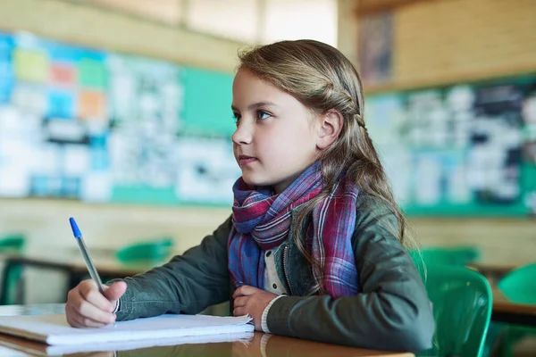 授業中はよく聞く。クラスで働く小学生の女の子のショット. — ストック写真