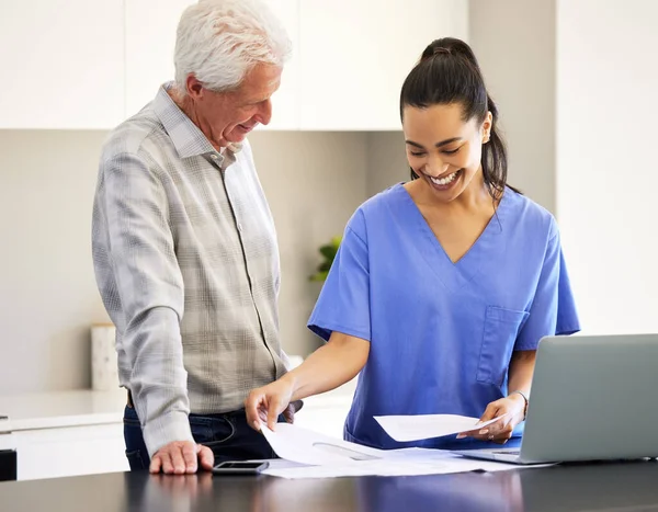 Thank you for helping me sort through this. Shot of a nurse going over paperwork with her senior patient. —  Fotos de Stock