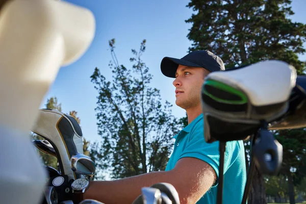 Choisir le bon club. Prise de vue d'un jeune homme concentré choisissant quel club de golf utiliser sur le terrain. — Photo