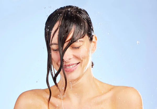 Не забудьте смыть весь негатив. Фотография молодой женщины, моющей голову в душе на синем фоне. — стоковое фото