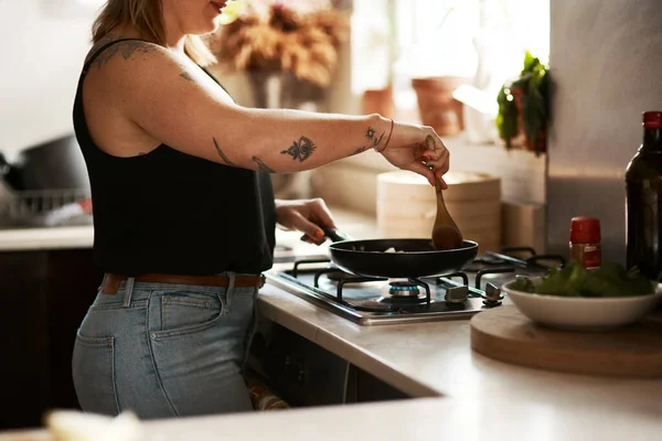 Mieszanie zapobiega przywieraniu. Ujęcie kobiety przygotowującej posiłek w domu. — Zdjęcie stockowe