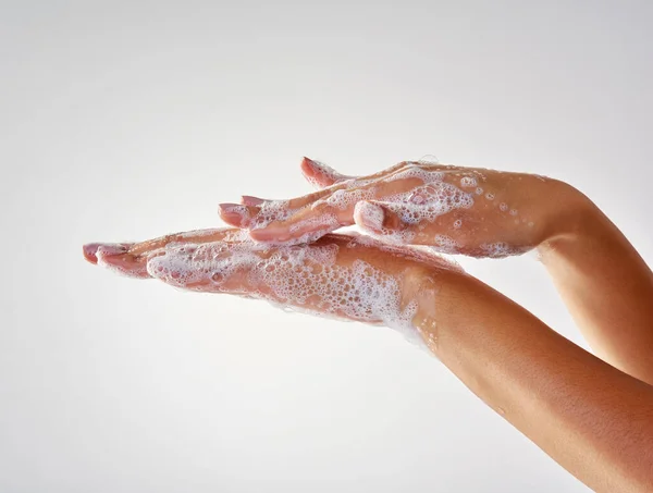 Хорошая гигиена необходима для здоровья. Обрезанный снимок рук, вымытый мылом на сером фоне. — стоковое фото