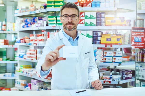 Tengo justo lo que necesitas. Retrato recortado de un guapo farmacéutico varón maduro que trabaja en una farmacia. —  Fotos de Stock