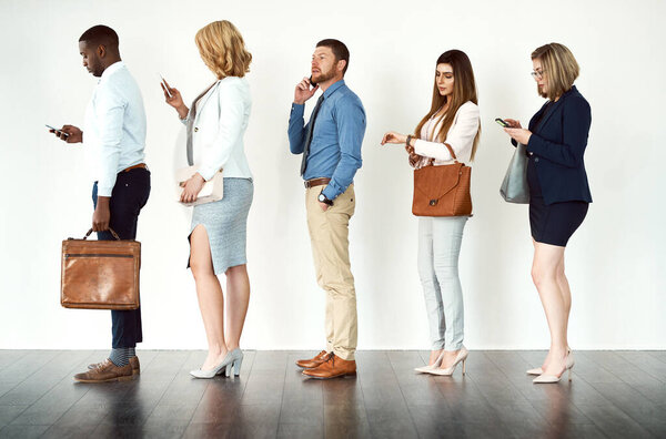 Theyre ready to get going. Studio shot of a group o focused people standing in a row behind each other against a white background.