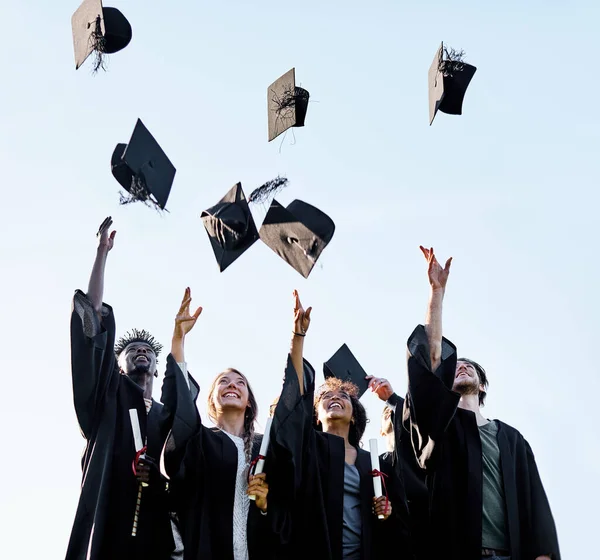 Rien ne bat ce sentiment d'atteindre vos objectifs. Tournage d'un groupe d'étudiants jetant leurs chapeaux en l'air le jour de la remise des diplômes. — Photo