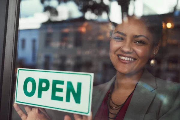 Elle a hâte d'accueillir tous ses clients. Portrait d'une jeune propriétaire d'entreprise accrochant un panneau ouvert sur la fenêtre de son café. — Photo