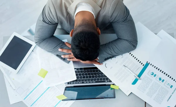 Estes prazos estão a esgotar-me. Foto de alto ângulo de um jovem empresário dormindo em sua mesa em um escritório. — Fotografia de Stock