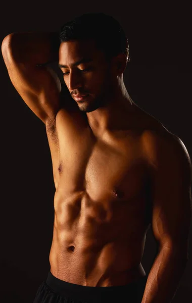 Stand back and watch me grow. Studio shot of a fit young man posing against a black background. — Foto de Stock