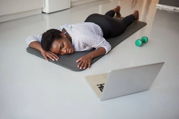 Це тренування насправді виснажує мене. Знімок молодої жінки, яка виглядає виснаженою під час фізичних вправ вдома . — стокове фото