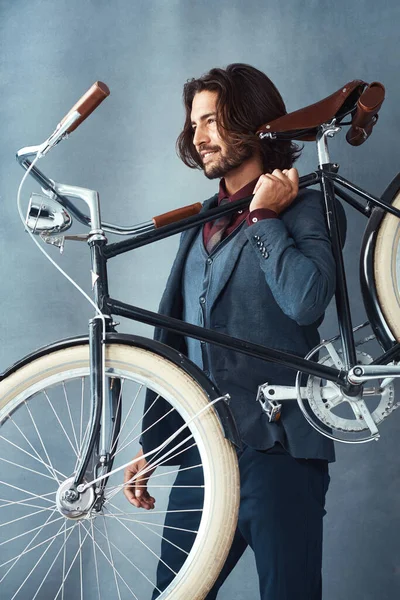 No rat race traffic for me. Studio shot of a stylishly dressed handsome young man carrying his bicycle against a gray background. —  Fotos de Stock