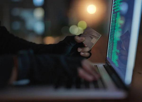 Hackers can do a lot without you knowing a thing. Shot of an unrecognisable hacker using a laptop to hack into a credit account. — Foto de Stock