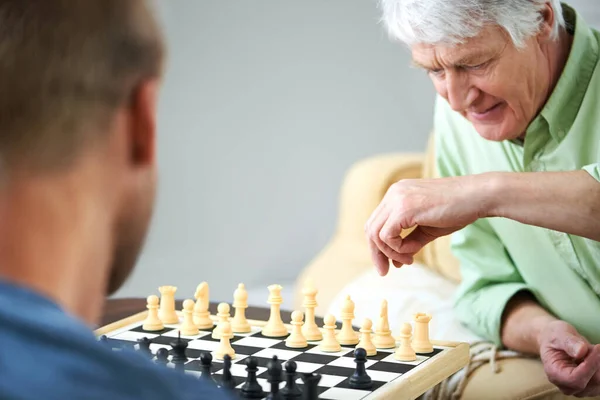 Leren van de kampioen schaken. Schaak van een vader en zoon die thuis een potje schaken spelen. — Stockfoto