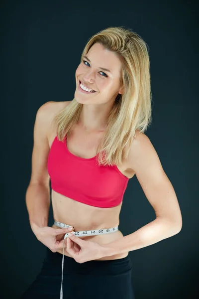 Mijn diëten werken zeker. Gesneden portret van een aantrekkelijke jonge vrouw meten van haar taille. — Stockfoto