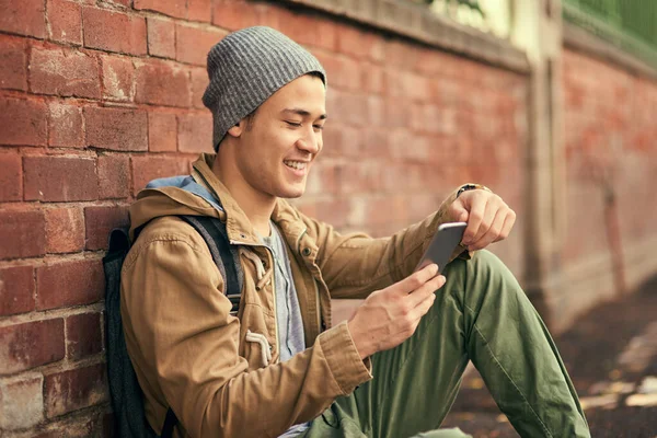 Lets see whos free to hang out. Cropped shot of a young man texting on his cellphone while out in the city. — ストック写真