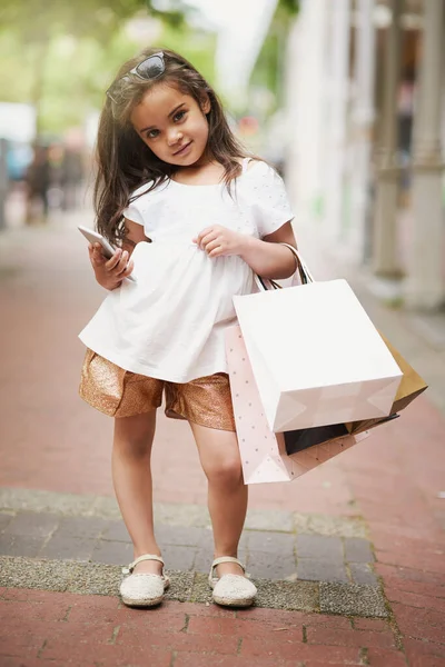 我们下一步该在哪里购物。一个在城里提购物袋的可爱小女孩的画像. — 图库照片