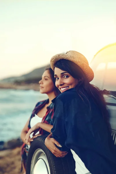 Ce road trip était exactement ce dont nous avions besoin pour nous détendre. Prise de vue de deux jeunes amis s'arrêtant à la plage pendant leur voyage. — Photo