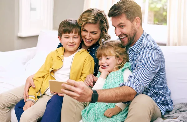 Somos el tipo de familia que constantemente se toma selfies. Una foto de una familia tomando una selfie en casa. —  Fotos de Stock