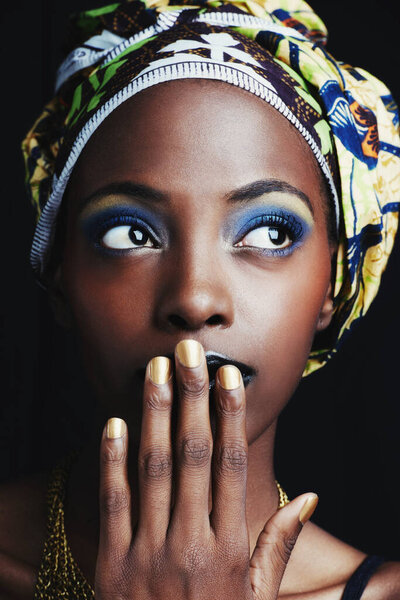 A beautiful african woman posing against a black background.