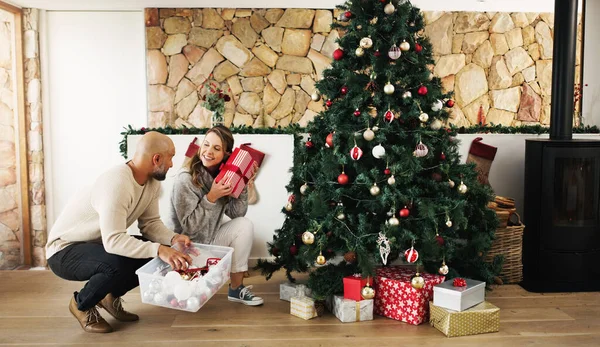 Это то, что я думаю. Съемка счастливой пары, украшающей елку и раскладывающей подарки дома. — стоковое фото