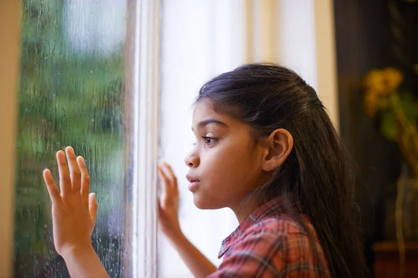 Ελπίζω να σταματήσει να βρέχει για να βγω έξω και να παίξω. Πυροβολισμός ενός χαριτωμένου μικρού κοριτσιού που κοιτούσε έξω από το παράθυρο μια βροχερή μέρα. — Φωτογραφία Αρχείου