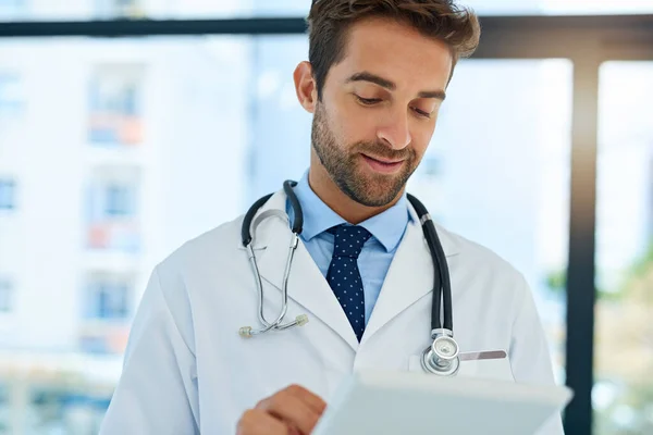 Obtener una segunda opinión en línea. Inyección de un médico ocupado revisando los registros médicos de los pacientes en su tableta. — Foto de Stock