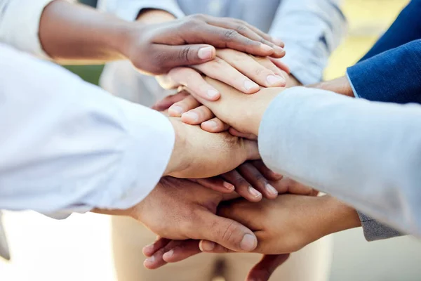 Never alone without love. Shot of a group of unrecognizable businesspeople stacking their hands together outside. —  Fotos de Stock