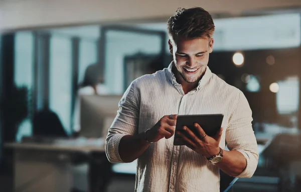 Niets drijft meer succes dan uiterste inzet. Foto van een jonge zakenman met een digitale tablet in een kantoor 's nachts. — Stockfoto