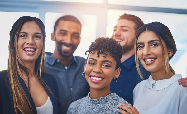 Estávamos a fazer ondas no mundo dos negócios. Retrato de um grupo alegre de jovens empresários sorrindo e posando juntos no trabalho. — Fotografia de Stock