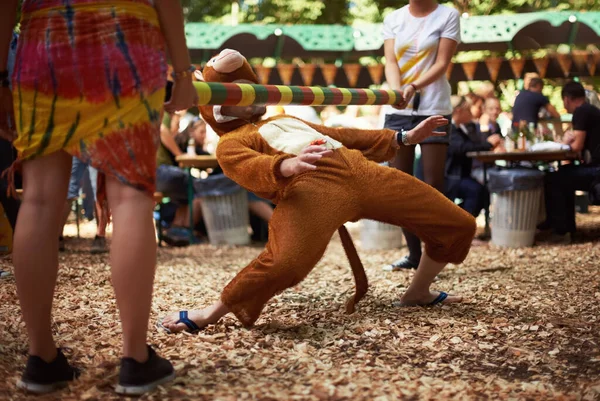 Majomkodik. Egy majomjelmezes fickó limbó táncot jár egy zenei fesztiválon.. — Stock Fotó