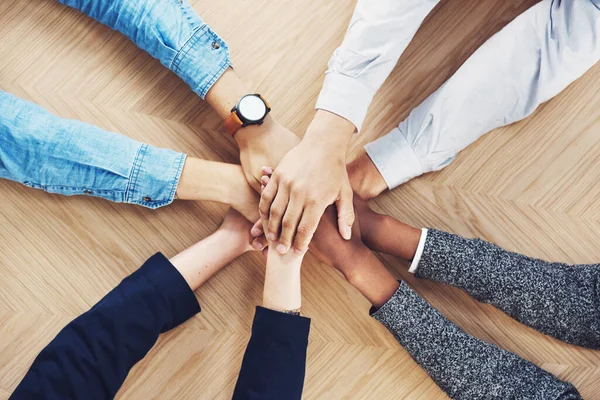 É mais fácil se o fizermos juntos. Foto de alto ângulo de um grupo de empresários não identificáveis unindo as mãos em unidade. — Fotografia de Stock