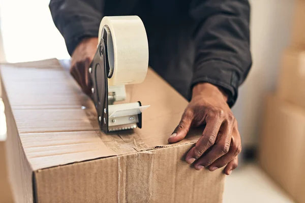 We take every step to protect your package. Closeup shot of an unrecognizable courier sealing a box with tape for delivery. — 스톡 사진