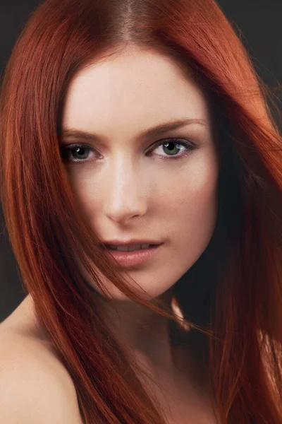 Red hot red hair. Portrait of a gorgeous young redheaded woman against a black background. — ストック写真