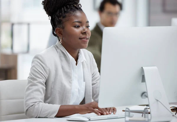 Finishing up her deadlines with determination. Shot of a young businesswoman working on a computer in an office. — Foto de Stock