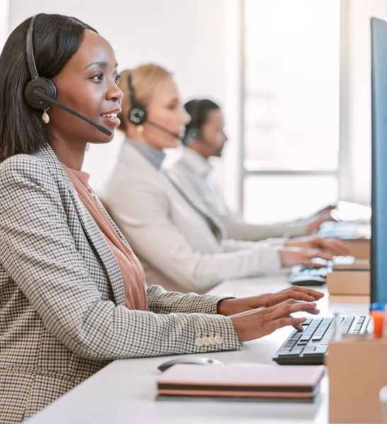 Theyre on call. Cropped shot of an attractive mature female call center agent wearing a headset while working in the office with her coworkers. — 스톡 사진