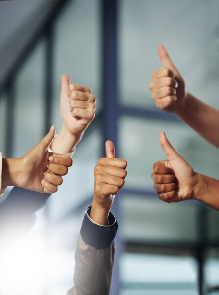 Great effort. Cropped shot of a group of unrecognisable businesspeople showing thumbs up.