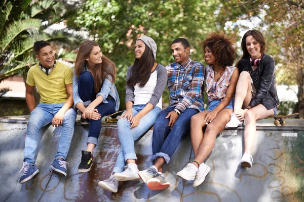 O que vamos fazer este verão? Tiro de um grupo de jovens amigos saindo em um parque de skate. — Fotografia de Stock