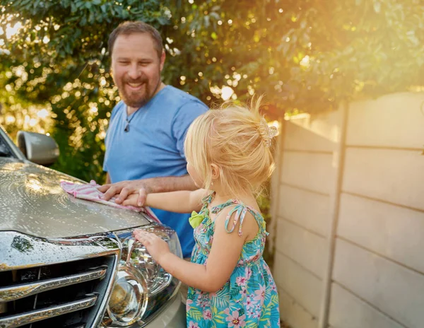 Doing chores together is a great bonding experience. Cropped shot of a father and daughter washing a car together. — Foto de Stock