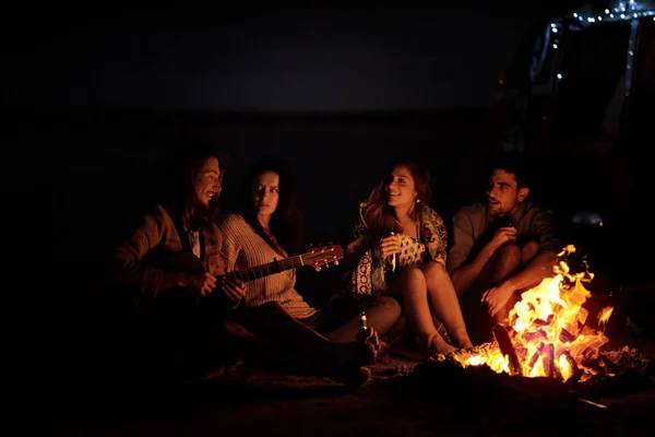 Questa è la sensazione di libertà. Girato di un gruppo di amici seduti intorno a un falò sulla spiaggia di notte. — Foto Stock