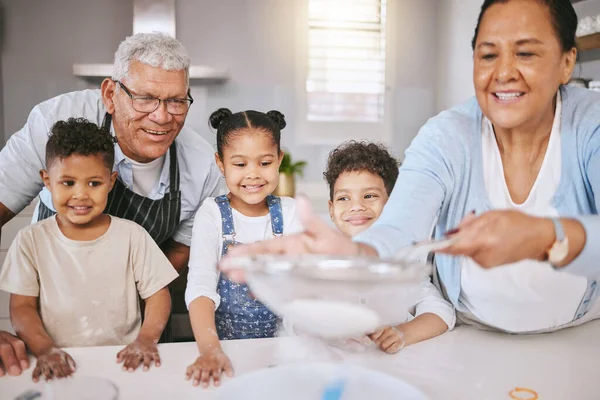 Familiegeheimen leren. Shot van een volwassen paar bakken met hun kleinkinderen thuis. — Stockfoto