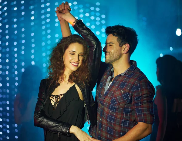 Dansar till kärlekens rytm. Skjuten av ett kärleksfullt ungt par som dansar tillsammans på en nattklubb. — Stockfoto