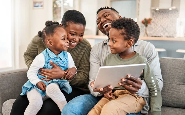 Familievriendelijke films zijn de beste jeugdherinneringen. Opname van een gelukkig jong gezin met behulp van een digitale tablet op de bank thuis. — Stockfoto
