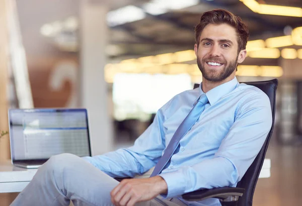 Upptagen med att bygga ett varumärke. Porträtt av en ung affärsman som sitter vid sitt skrivbord på ett kontor. — Stockfoto